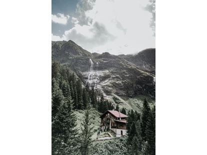Hochzeit - nächstes Hotel - Tirol - Ein magischer Blick auf die Grawandhütte 🏔✨
Hoch oben in den Zillertaler Alpen liegt die Grawandhütte, eingebettet in eine Landschaft, die pure Schönheit und Ruhe ausstrahlt. Dieses Drohnenbild fängt die besondere Magie dieses Ortes perfekt ein: eine urige Hütte, umgeben von saftig grünen Almwiesen, mit einem atemberaubenden Blick auf die Berge.
Im Hintergrund erhebt sich majestätisch der Hohe Greiner, dessen schroffe Gipfel in den Himmel ragen. Direkt darunter stürzen glitzernde Wasserfälle die Felswände hinab und verleihen der Szenerie eine wilde, unberührte Note. Die Sonnenstrahlen tauchen die Landschaft in ein warmes, goldenes Licht, während eine sanfte Brise durch das Tal weht.
Die Grawandhütte wirkt wie ein kleines Paradies in den Bergen – ein Ort, an dem man die Natur in ihrer schönsten Form erleben kann. Hier oben scheint die Zeit stillzustehen, und jeder Moment wird zu einer wertvollen Erinnerung. 🌿💛 - Grawandhütte