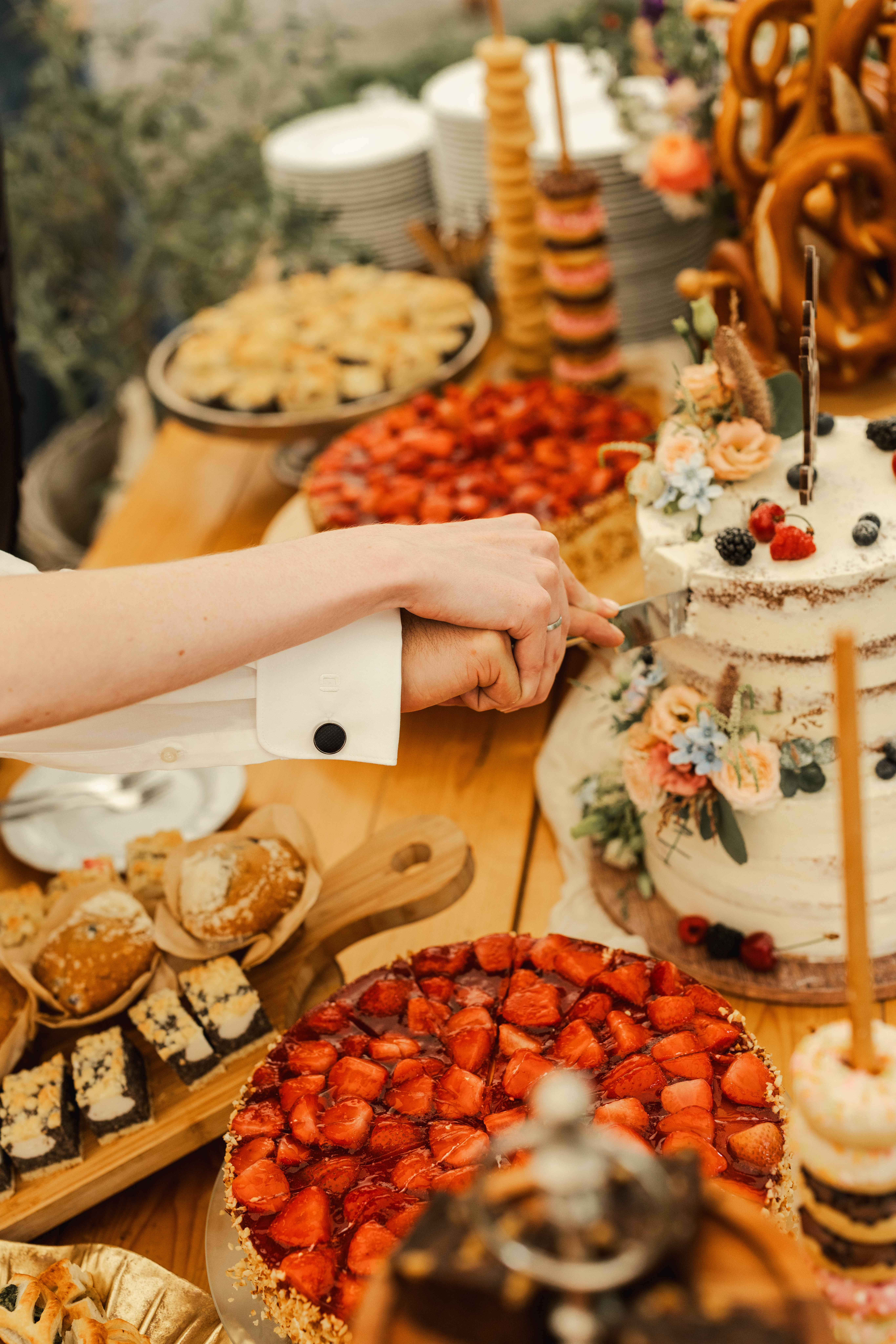 Hochzeitslocation: Anschnitt Hochzeitstorte im Außenbereich unter unserem Stretchtent - Unter Freunden | Genuss & Events