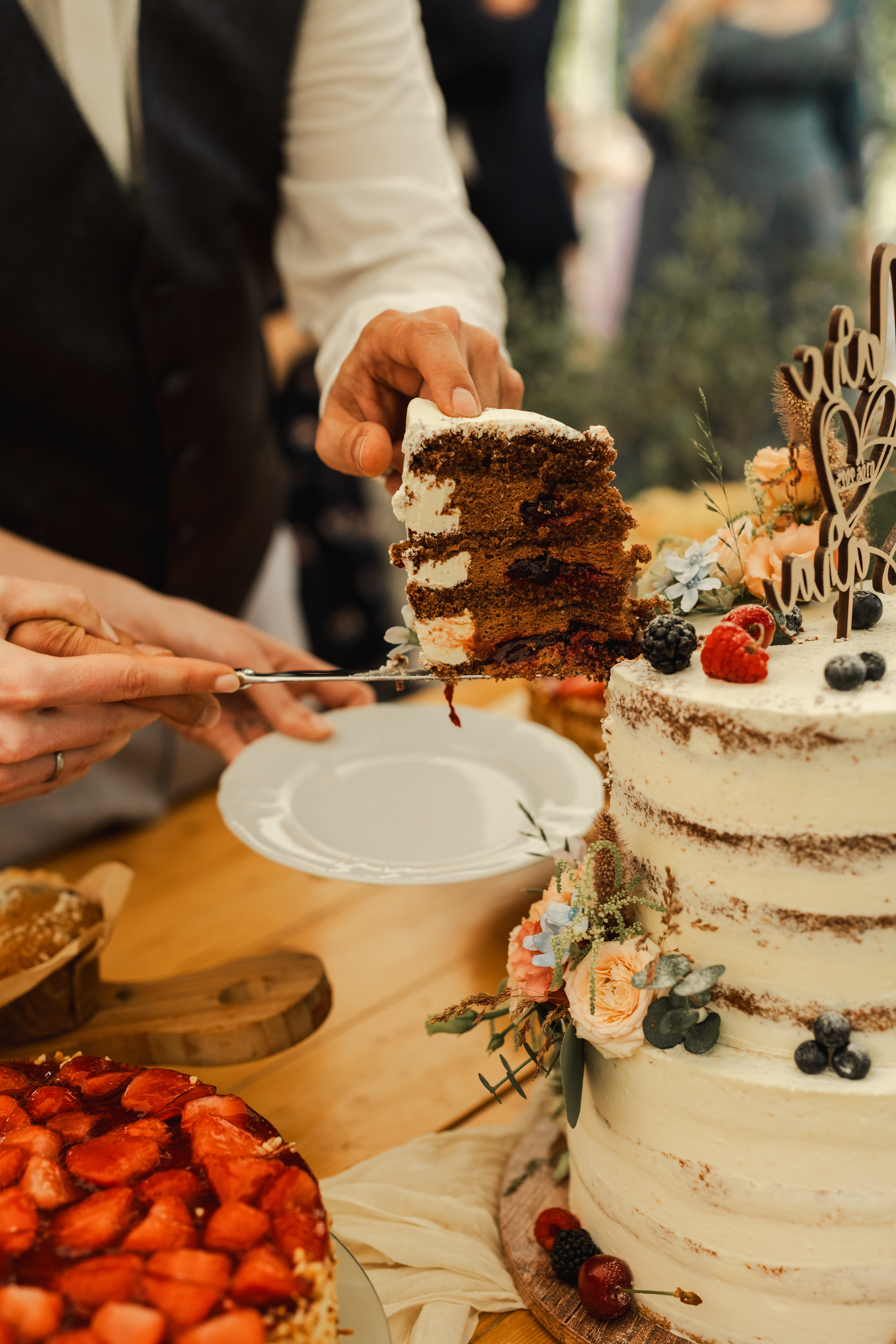 Hochzeitslocation: Anschnitt Hochzeitstorte im Außenbereich - Unter Freunden | Genuss & Events