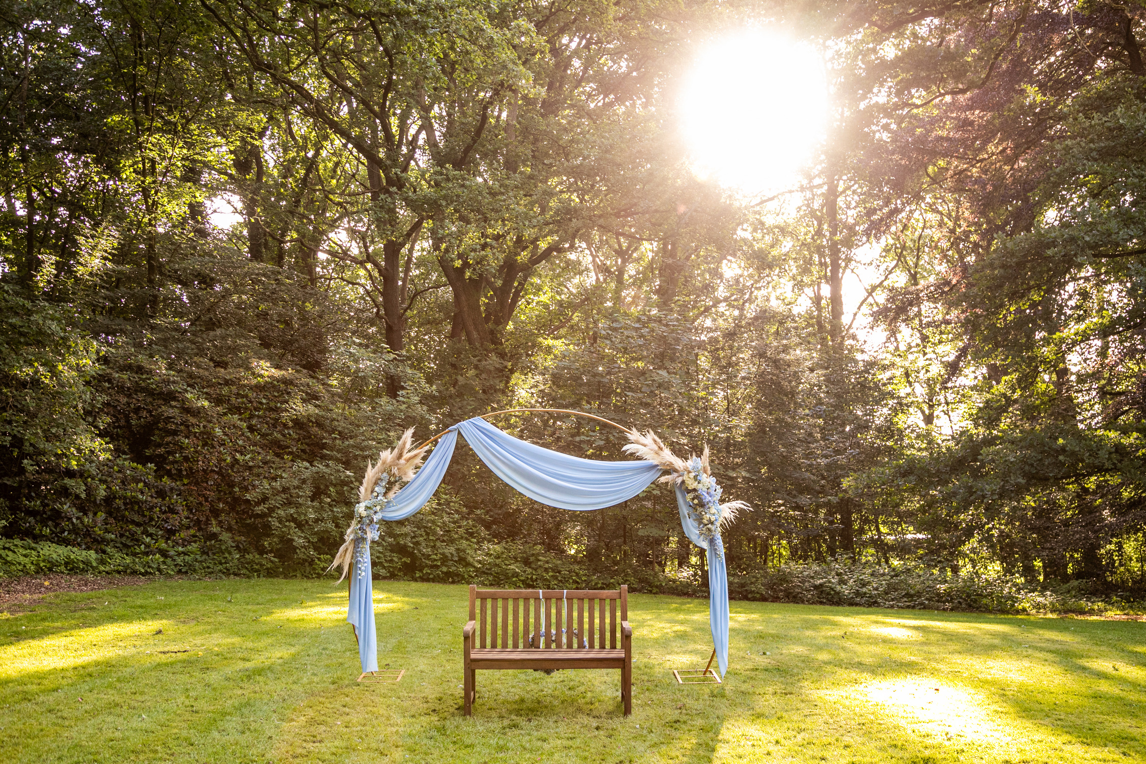 Hochzeitslocation: Traubogen und Bank vor den Rhododendren - Landsitz Maleksberg