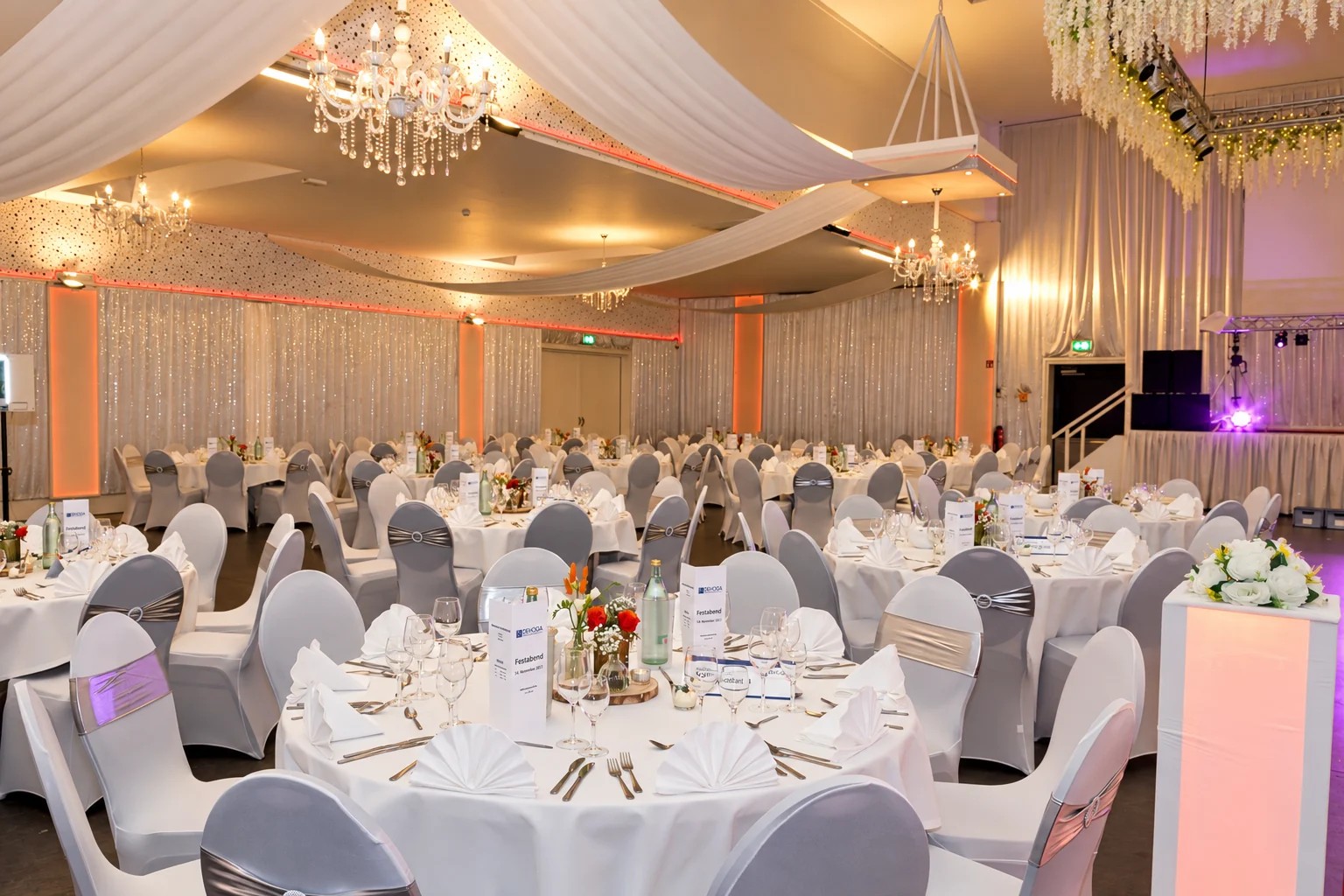 Bruiloft - Aurich - Festsaal mit Deckentüchern, Kronleuchtern und runden Tischen - Metadrom Eventcenter