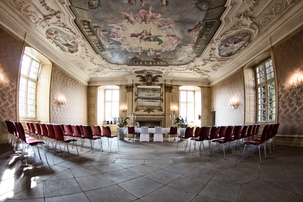 Hochzeitslocation: Barocksaal: 
Wohl einer -wenn nicht sogar- der schönste Raum im ganzen Schloss. Die herrliche Stuckdecke mit den tollen innenliegenden Gemälden, hochwertige Stofftapeten und ein imposanter Marmorkamin lassen den Prunk vergangener Zeiten erahnen. Der Barocksaal ist der beliebteste Raum für eine standesamtliche Trauung und bietet Platz für bis zu 90 Gäste. Gerne wird dieser Raum aber auch für Seminare, Empfänge oder andere Festlichkeiten genutzt. Bei unseren Hochzeitgesellschaften dient dieser Raum nicht nur als Buffetbereich, sondern gerne werden hier auch die Cocktailbar, eine Candybar, ein Kindertisch oder sonstige „Specials“ passend zur jeweiligen Hochzeit aufgebaut. - Schlossgastronomie Herten