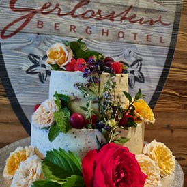 Hochzeit: Naked Cake mit frischen Kräutern, Früchten und Blumen passend zum Brautstrauß. - Berghotel Gerlosstein