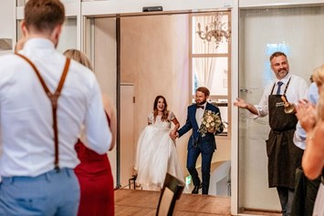 Hochzeit: Das Brautpaar kommt in den Dinner Saal und wird von den Gäste mit stehenden Applaus erwartet. - Schloss Maria Loretto am Wörthersee