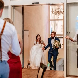 Hochzeit: Das Brautpaar kommt in den Dinner Saal und wird von den Gäste mit stehenden Applaus erwartet. - Schloss Maria Loretto am Wörthersee