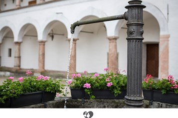 Hochzeit: Blühende Sommerblumen am plätschernden Brunnen im Schlosshof.  - Landschloss Parz